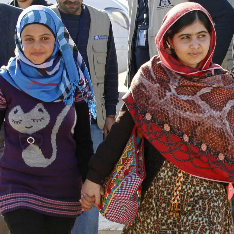 Malala holding hands with a refugee